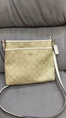 Bolsa Coach crossbody original, em canvas Signature bege com detalhes claros.