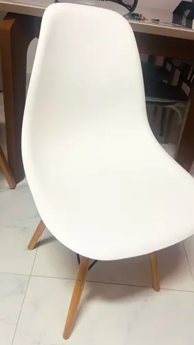 Cadeira branca estilo Eames com pés de madeira