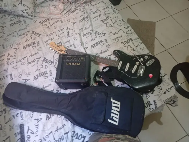 Guitarra preta com amplificador meteoro