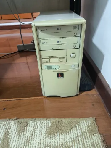 Computador antigo com teclado, mouse, caixas de som, e monitor. Para colecionadores.