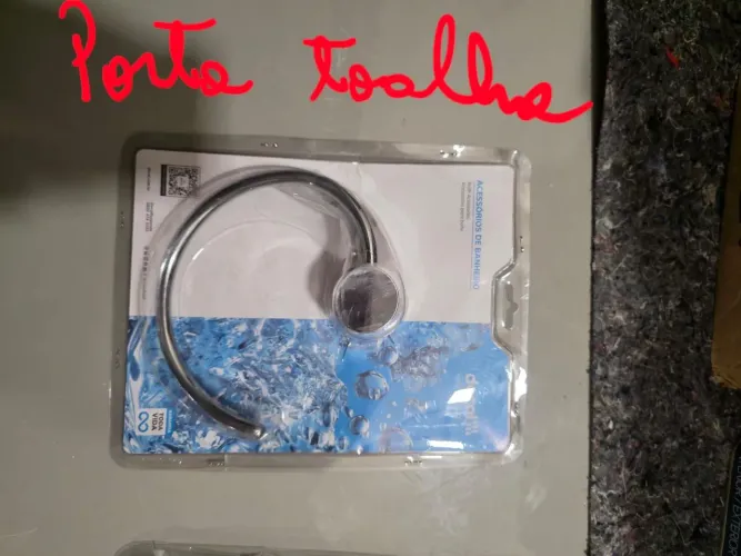 Porta toalha em formato de gancho na caixa da Docol.