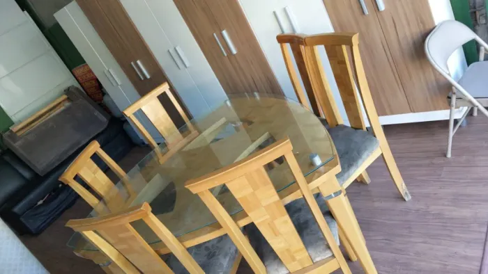 Mesa de vidro triângular com 6 cadeiras estofadas
