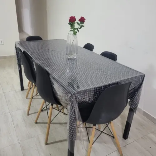 Mesa de jantar retangular preta, com cadeiras de pé de palitos. Linda
