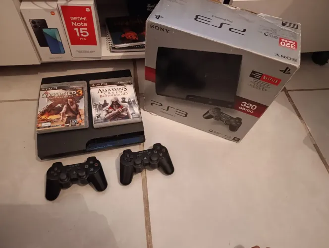 Ps3 com desbloqueio hen NA CAIXA com 2 controles originais e 2 jogos originais com encarte