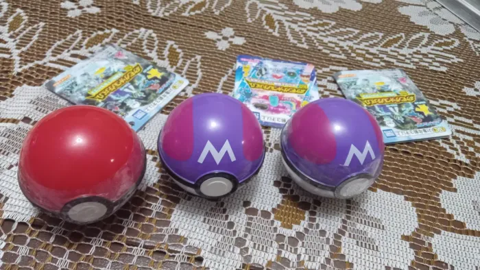 Três pokebolas originas duas lacradas e uma aberta contendo miniaturas de Pokémon