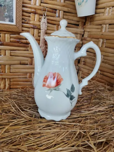 bule de porcelana branca decorado com uma estampa floral em tons de laranja