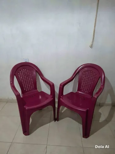 Duas cadeiras plásticas com apoio de braço.