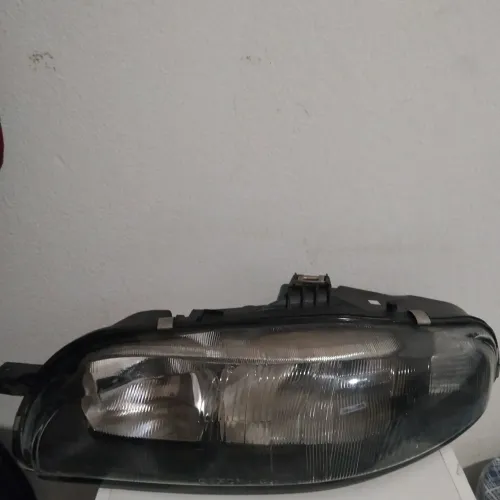 Farol Esquerdo Fiat Marea lente vidro raiada, foco de corte no vidro.  
