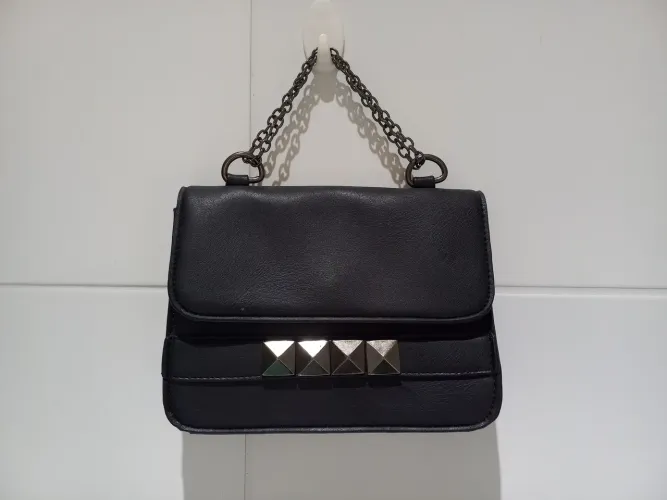 Bolsa de mão preta com detalhes em metal
