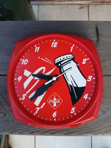 Relógio de parede vibrante em vermelho com o icônico logotipo da Coca-Cola.