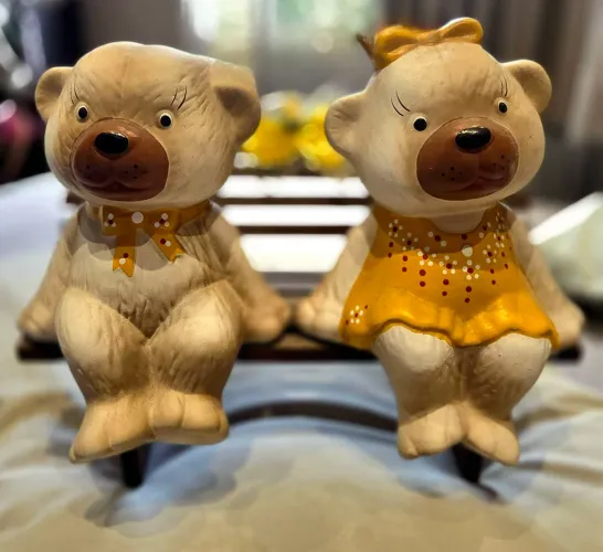 casal de ursos em cerâmica sentados em um banquinho de MDF.