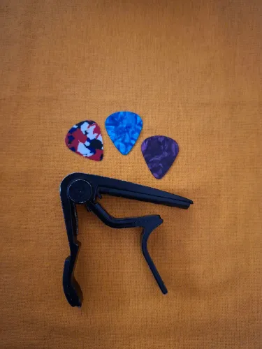 Capo traste para violão mais um jogo de palheta. 