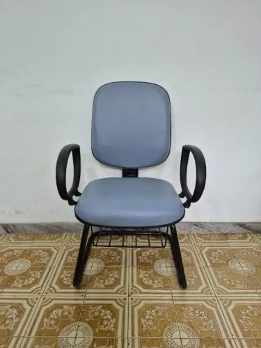 Cadeira Poltrona Diretor Riazor Fixa Almofadada em Courino Cinza com Porta Livros Usada