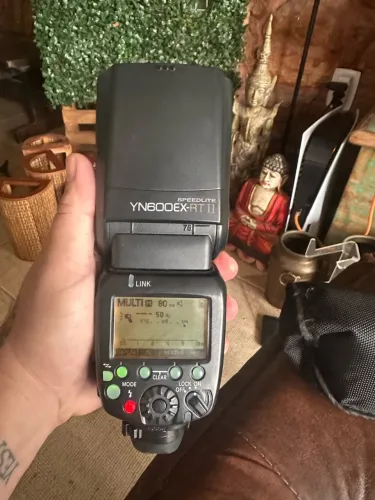 O flash exibido na imagem parece ser um Yongnuo YN600EX-RT II Speedlite para câmeras Canon