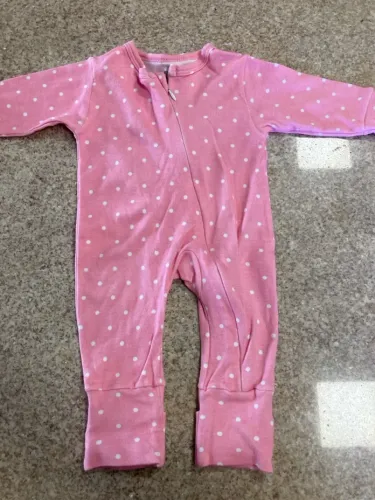 Macacão de bebê rosa com bolinhas