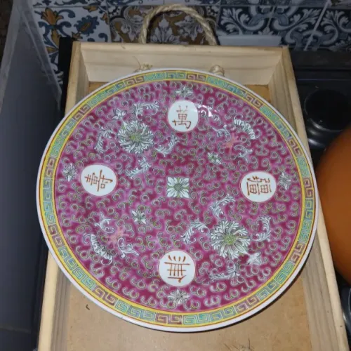 prato magenta com motivos florais e caracteres chineses em medallhões