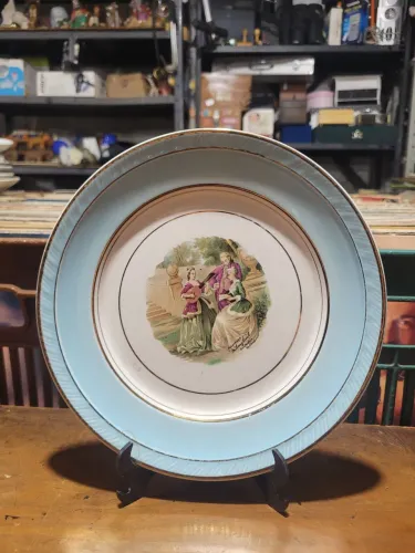 Belíssimo prato decorativo em porcelana Nadir, com cenas galante central