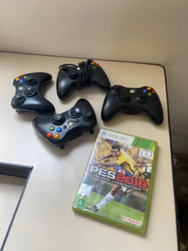 4 manetes de Xbox 360 e um jogo PES 