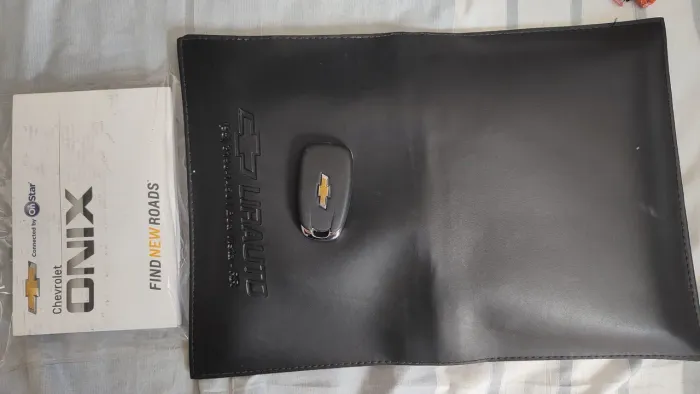 Chave do Onix 2020 e uma pasta de documentos com o manual