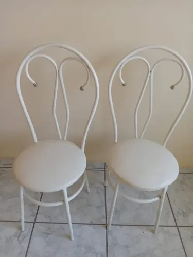 Duas cadeira em metal tubular assento estofado.