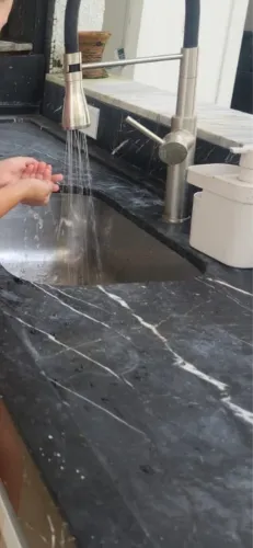 Pia de granito preta com torneira.