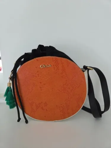 Bolsa transversal redonda CS Club laranja com detalhes em preto e um pingente