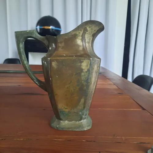 Jarra antiga em metal com formato facetas