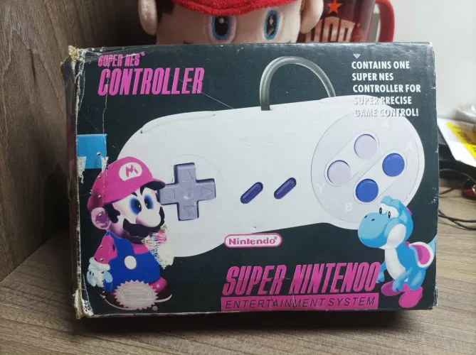 Controle de Super Nintendo paralelo de época com caixa