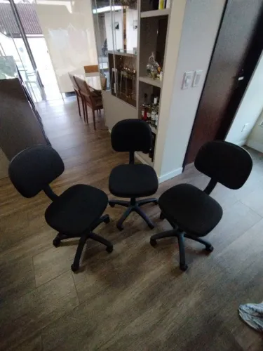 Três cadeiras de escritório seminovas.