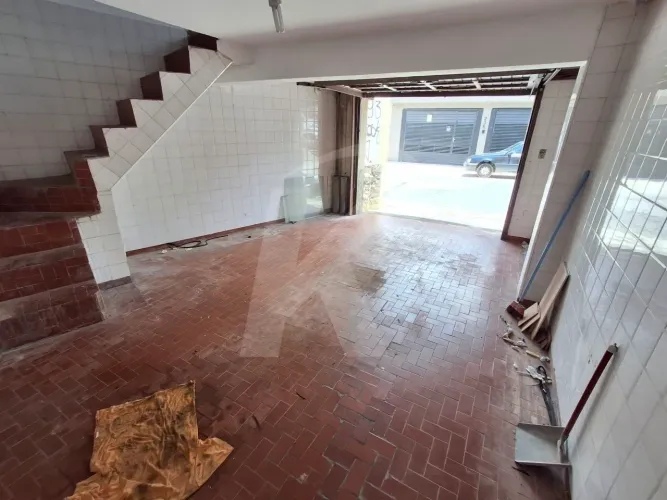 Salão comercial com 2 banheiros e porta de aço.