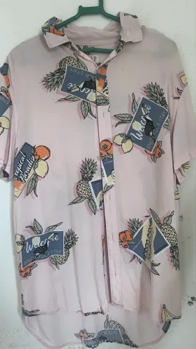 camisa de manga curta rosa claro com estampa tropical de abacaxis e limões da Riachuelo.