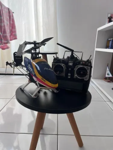 É um aeromodelo um t-rex 450<br>O controle é profissional e são<br>18 canais!