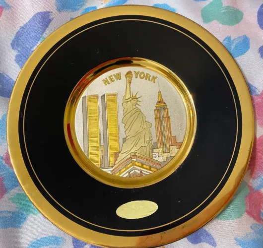 Prato com cena de Liberdade Nova York com borda dourada.