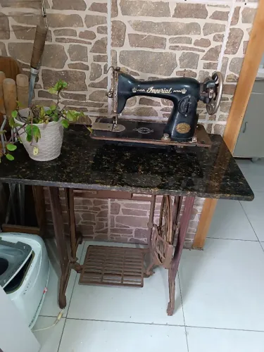 Máquina antiga Imperial e pé de ferro.