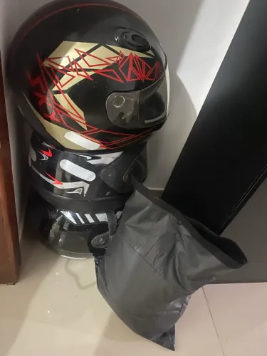Capacete usado e capa chuva