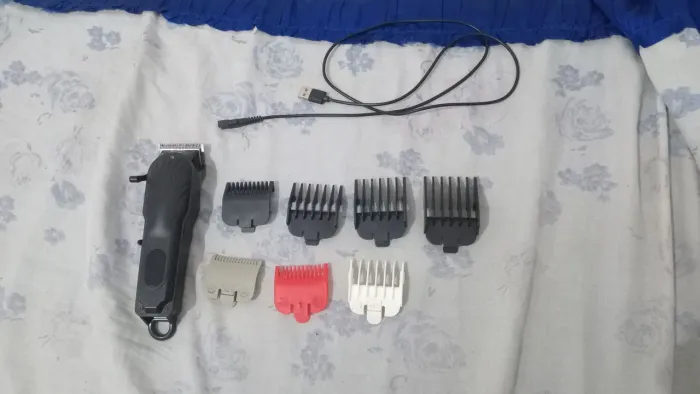 Maquina de corta cabelo acompanhada com pentes.
