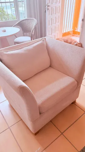Poltrona estofada bege ampla e confortável 
