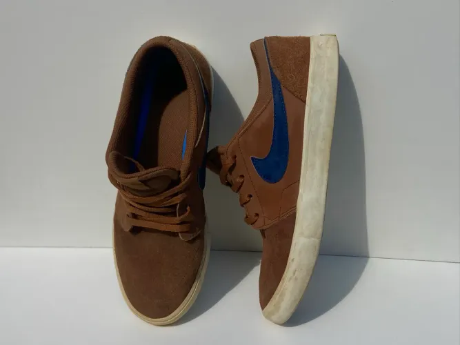 Nike SB Portmore II Solar camurça marrom com um swoosh azul.