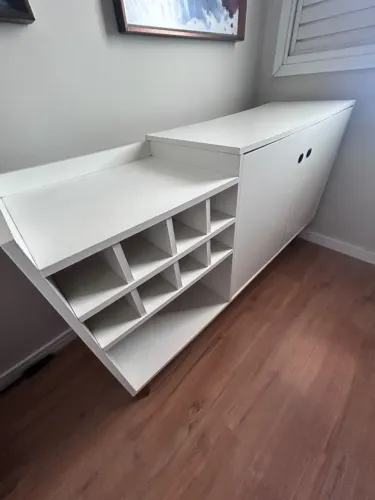 Armário baixo branco, com duas portas e nichos organizadores laterais.