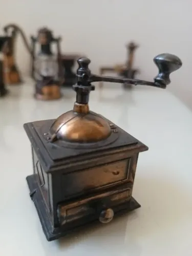 Miniatura moedor de café antigo em ferro apontador