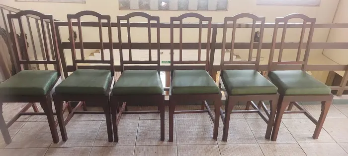 Conjunto de 6 cadeiras de madeira escura com estofado verde escuro para mesa de jantar.