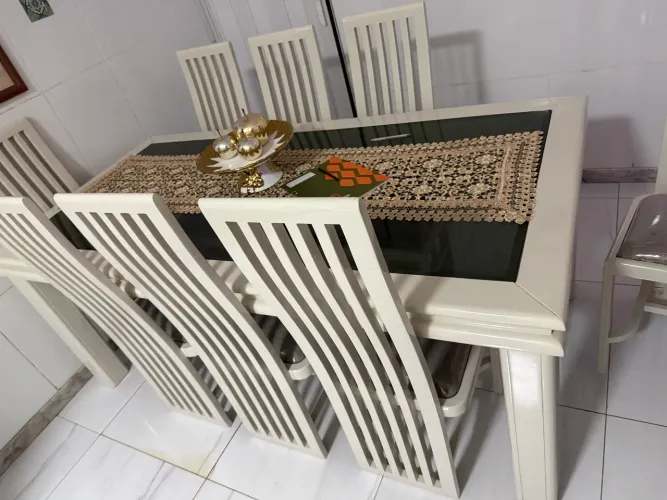 Mesa de madeira e tampo de vidro com 8 cadeiras.