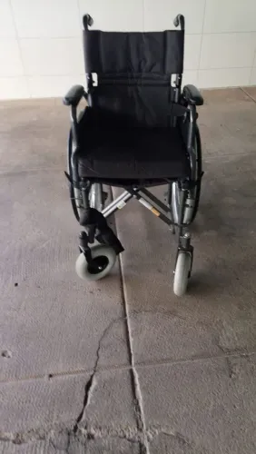 Cadeira de Rodas semi-nova com cinto de segurança e apoio para os pés.