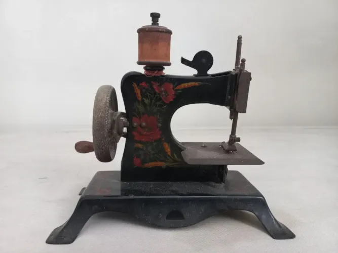 Máquina de costura de brinquedo antiga em miniatura