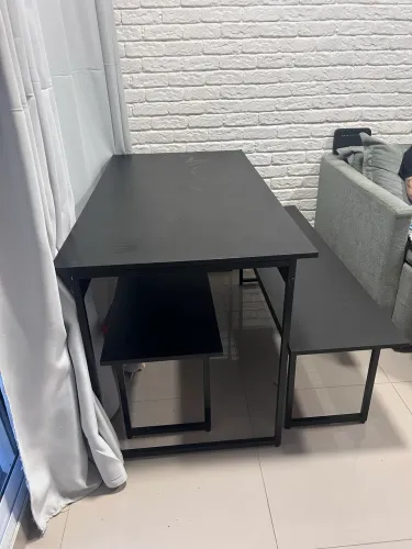 Mesa preta com dois bancos estilo industrial