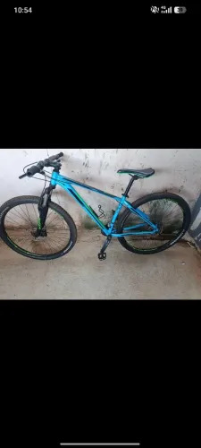 Esta é uma mountain bike Groove Hype 70 aro 29 na cor azul com detalhes em verde e preto