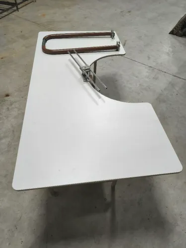 Mesa com gabarito para revisão de peças de vestuário