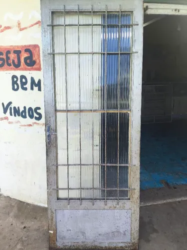 Porta de ferro com grade de proteção.