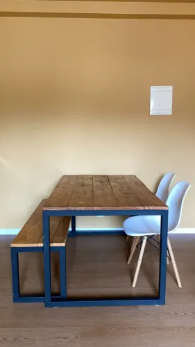 Mesa industrial com duas cadeiras e um banco