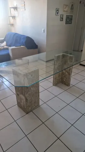 Mesa de vidro com suportes de mármore.